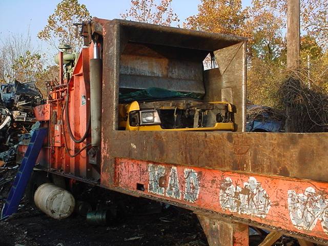 A car crusher working through junk vehicles